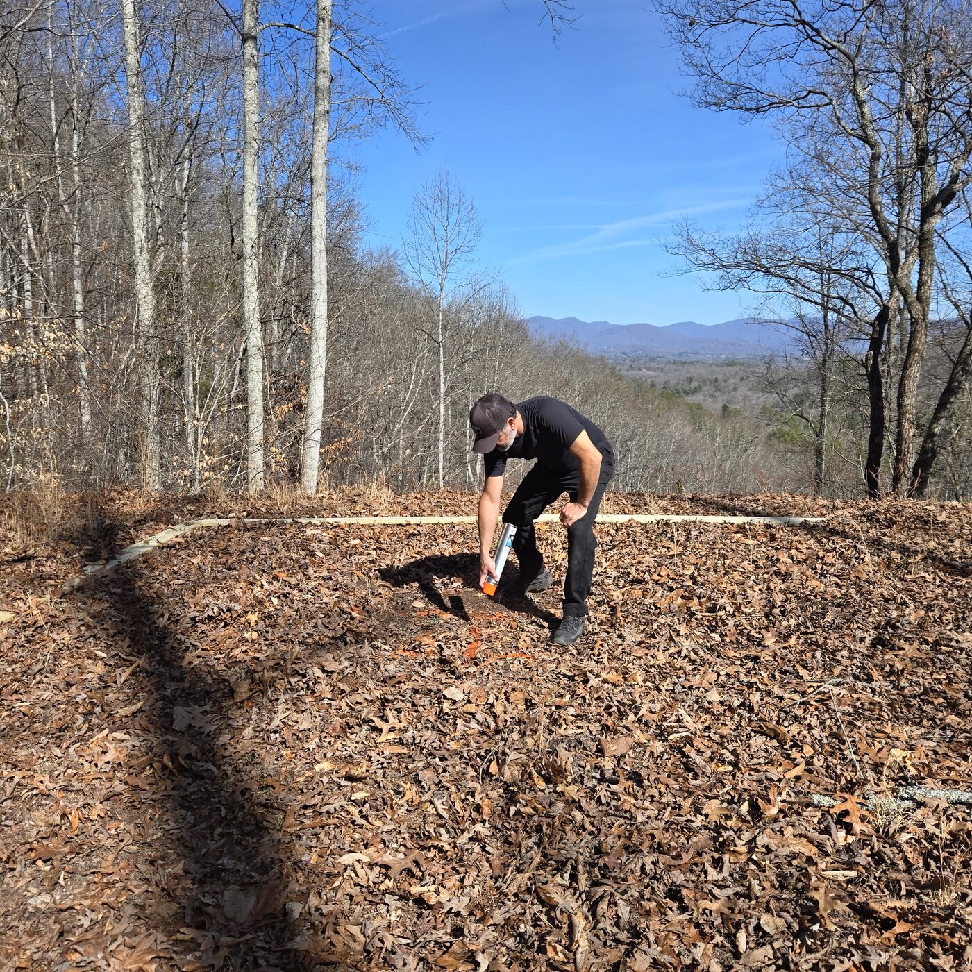 Marking out a campsite at Cardinal Mountain Campground near Franklin, NC, with the Blue Ridge on the horizon behind the bare winter trees