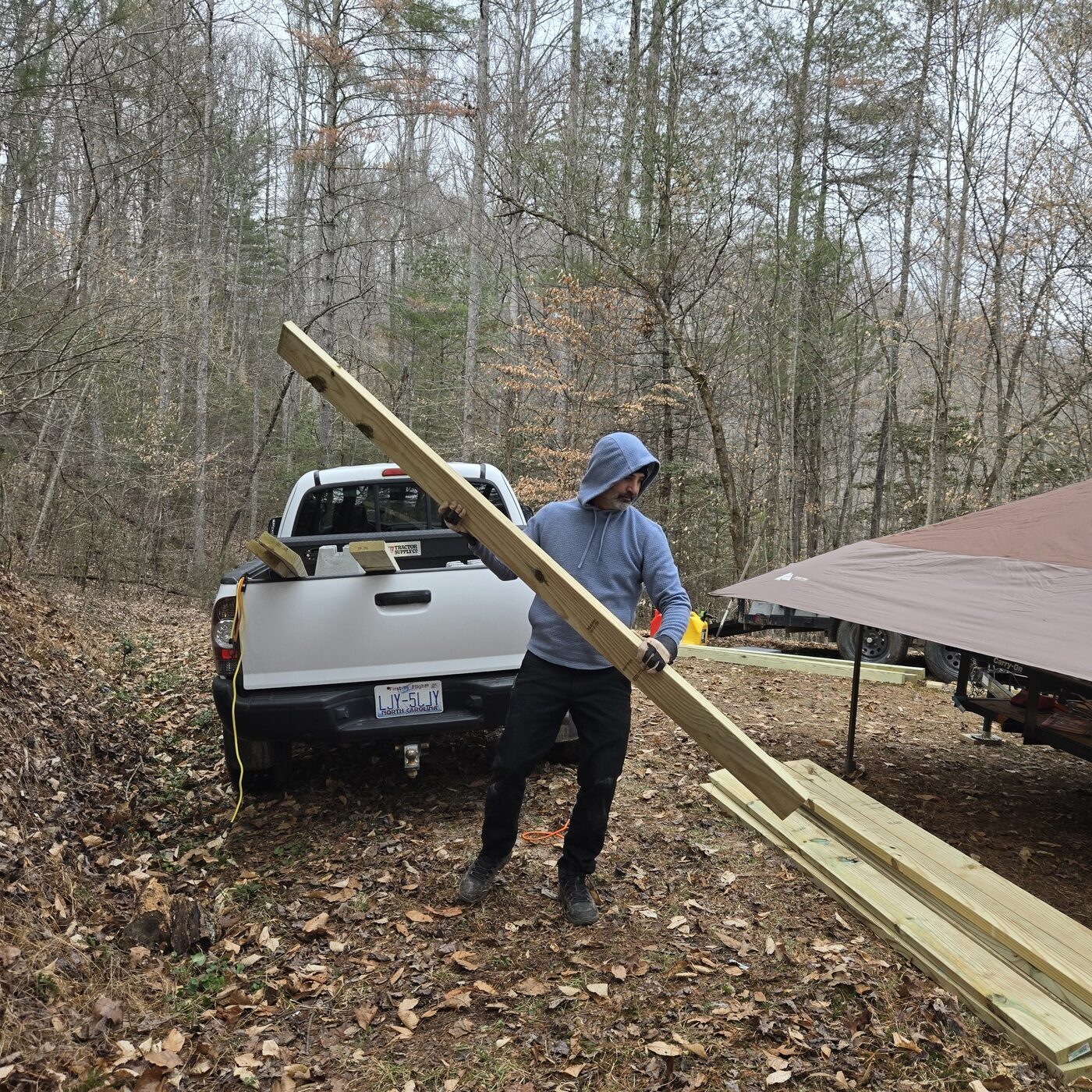 Carrying pressure-treated lumber from a pickup truck at the Cardinal Mountain Campground build site near Franklin, NC