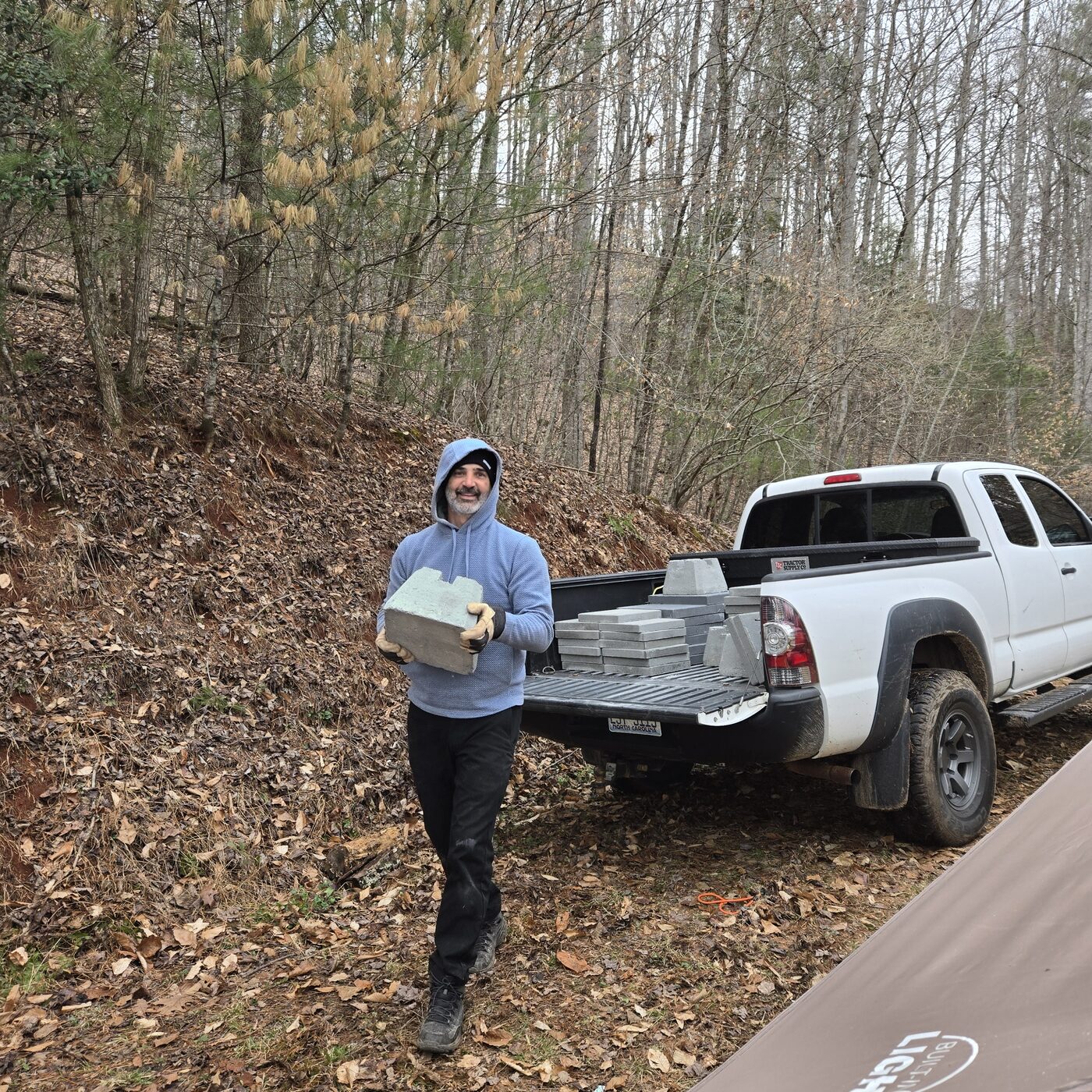 Carrying a concrete deck pier from a truck bed at Cardinal Mountain Campground
