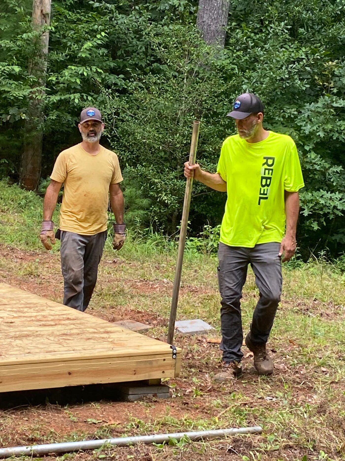 Two builders levelling a newly placed tent deck at Cardinal Mountain Campground near Franklin, NC