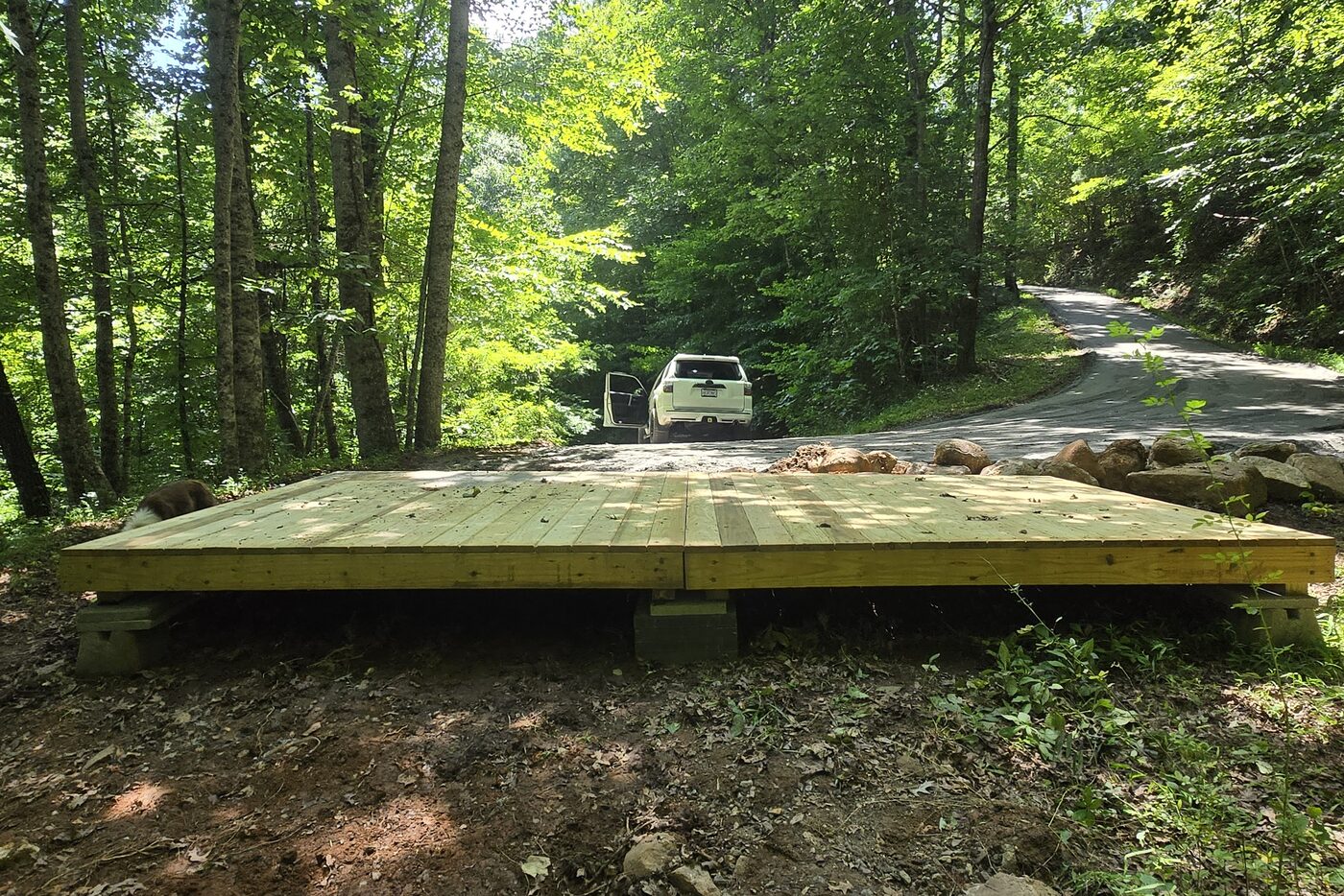 Rockies 7 at Cardinal Mountain Campground, showing a vehicle parked on the paved road alongside the decks