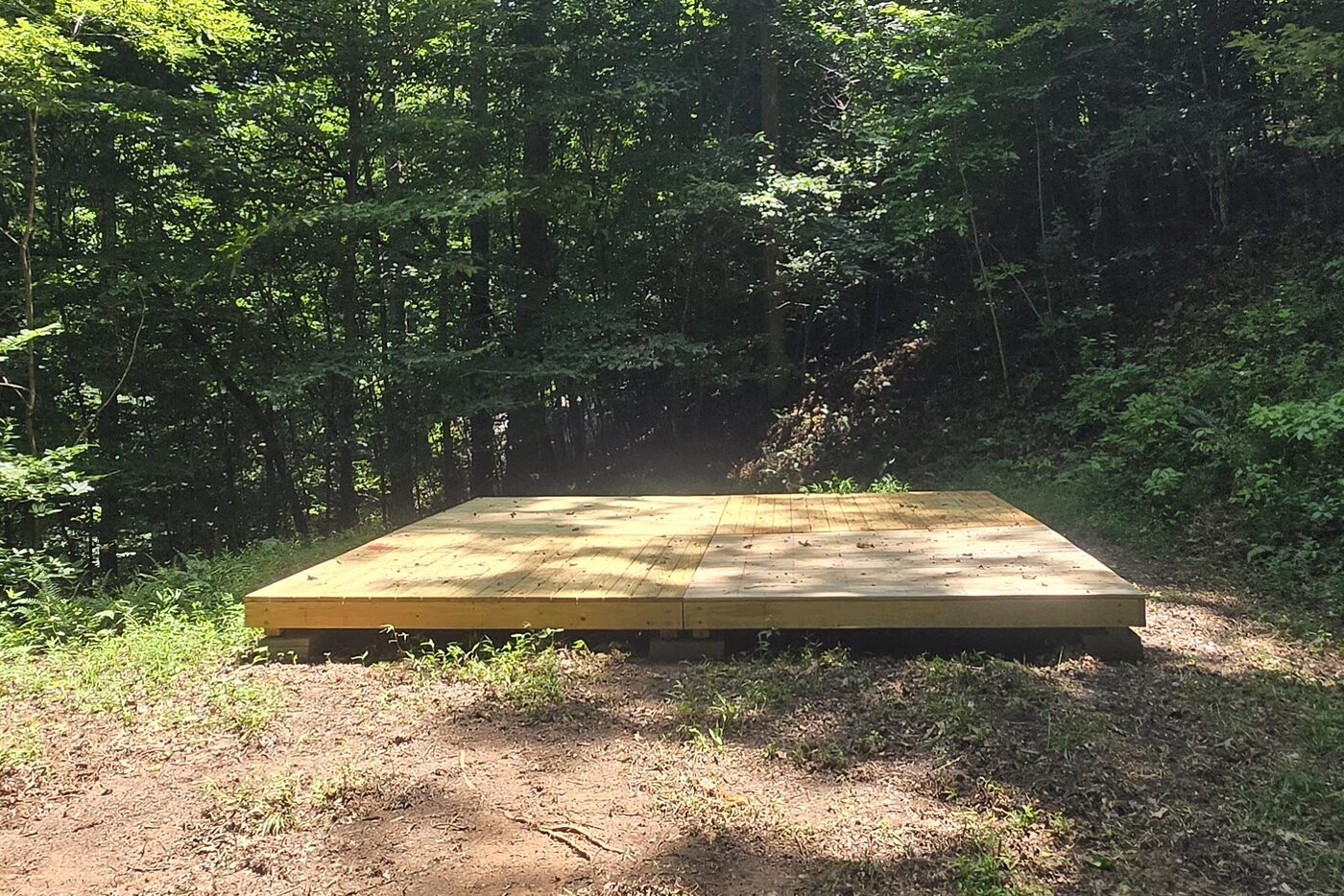 The 16 by 16 tent deck at Zion 8, Cardinal Mountain Campground, with green woods on every side