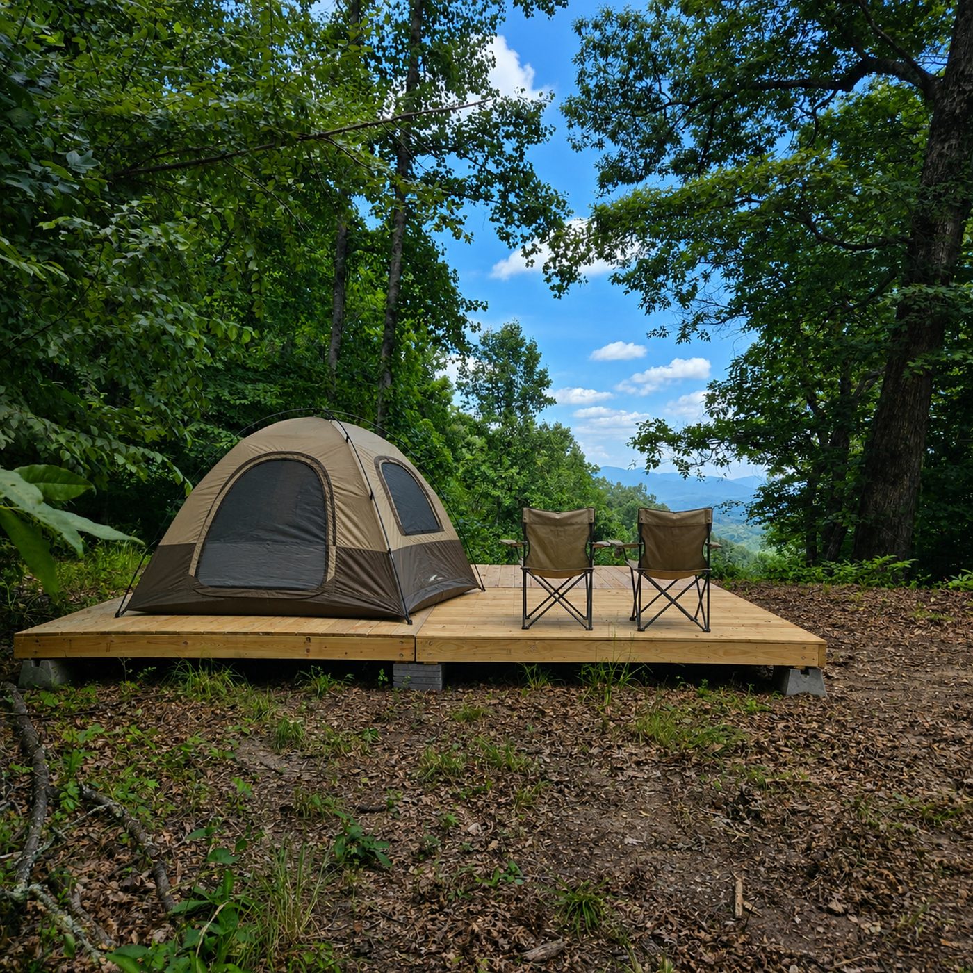 A tent and two camp chairs on the deck at Katahdin 9, Cardinal Mountain Campground near Franklin NC, with the ridges beyond the open edge of the site