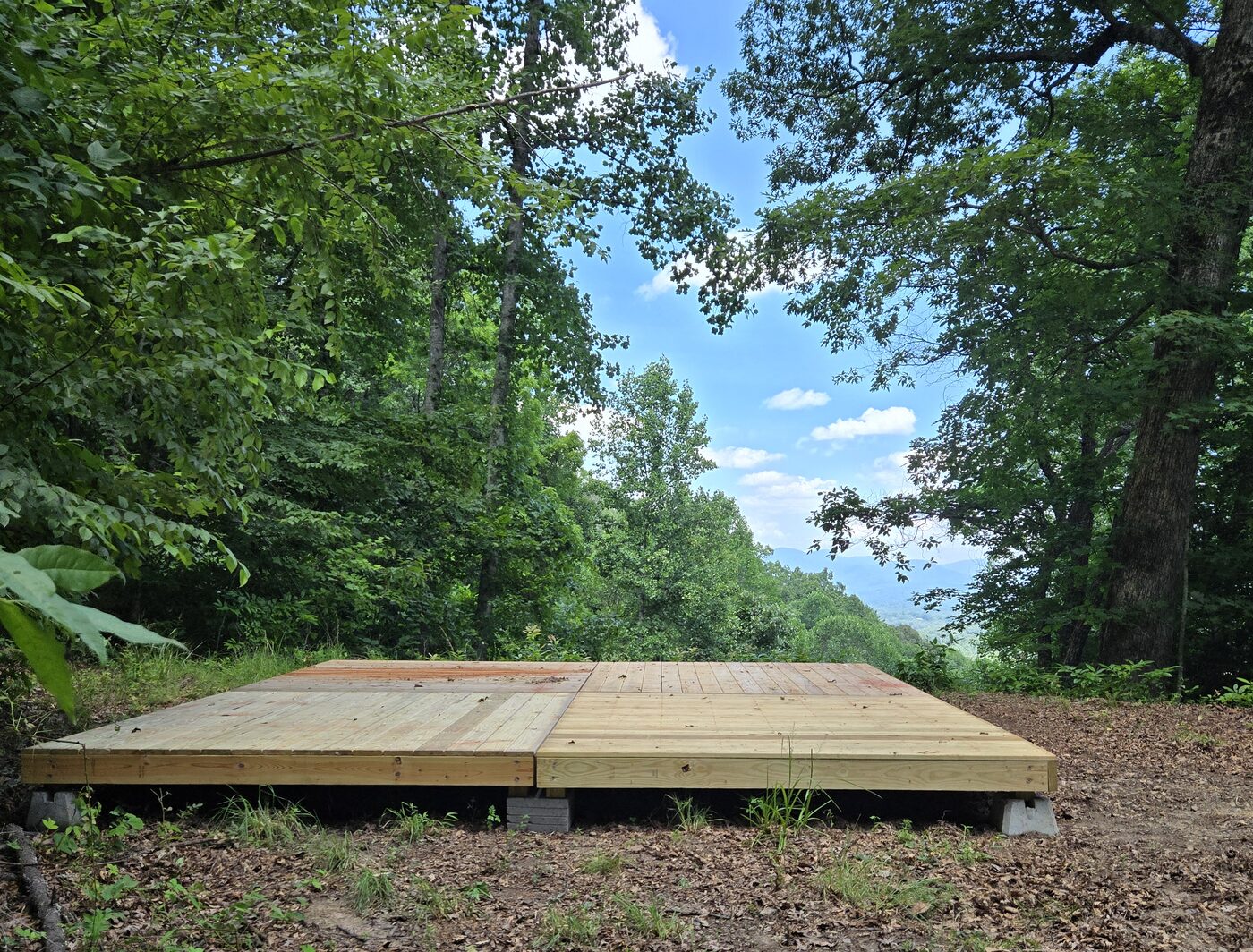 The tent deck at Katahdin 9, Cardinal Mountain Campground, with the cleared opening beyond it
