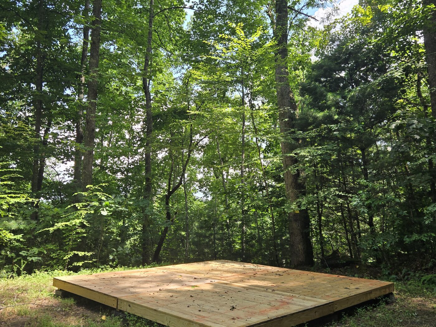 The tent deck at Nantahala 10, Cardinal Mountain Campground, ringed by summer woods