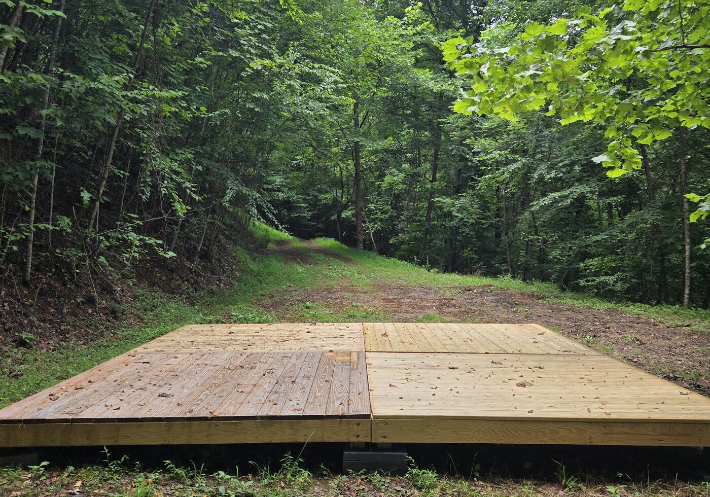 The 16 by 16 tent deck at Sequoia 11, Cardinal Mountain Campground, with the pull-in behind it