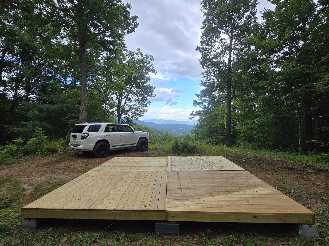 The deck and parking at Big Bend 14, Cardinal Mountain Campground, with the ridgeline beyond
