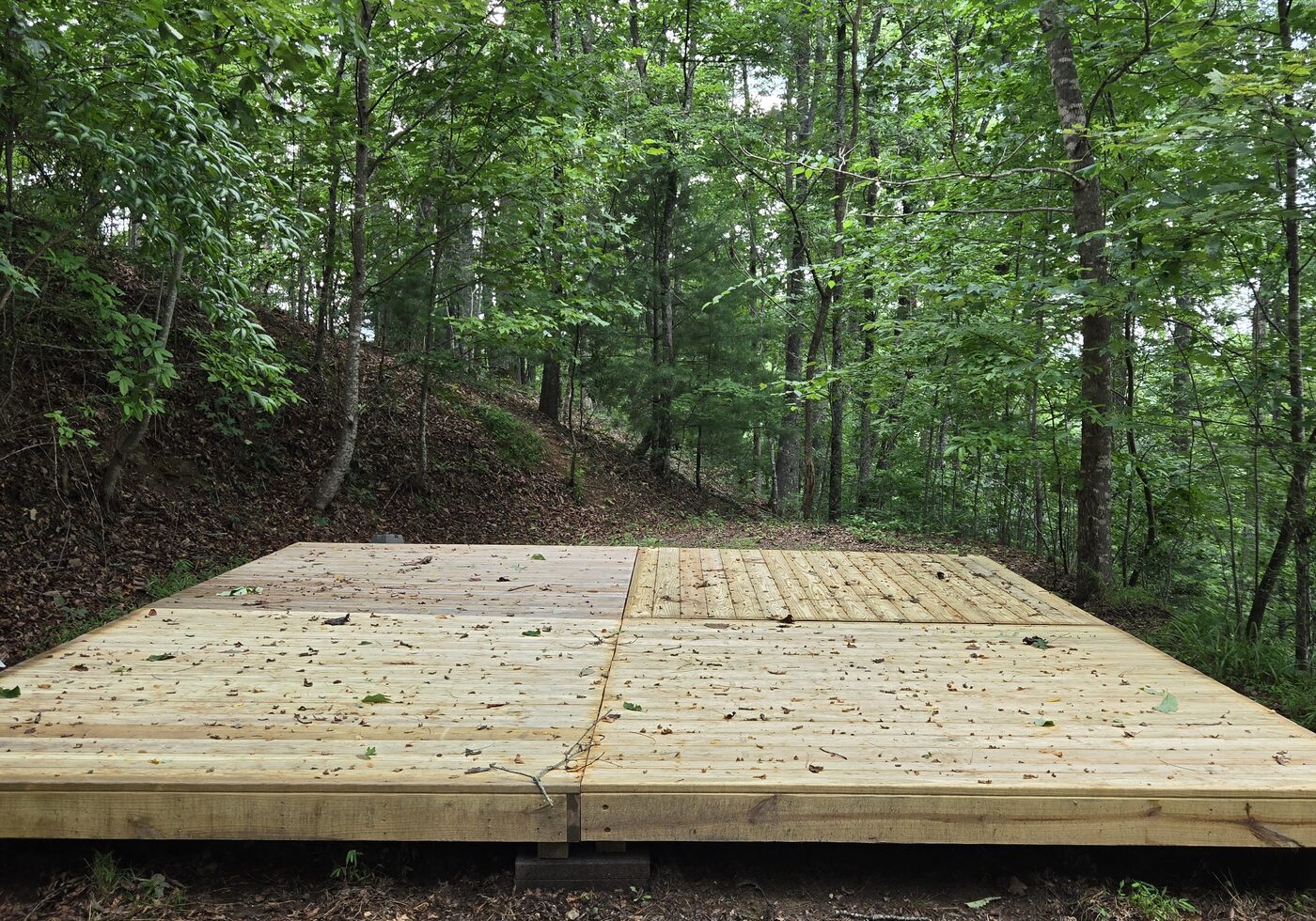The deck at Pisgah 16, Cardinal Mountain Campground, with the wooded bank rising behind