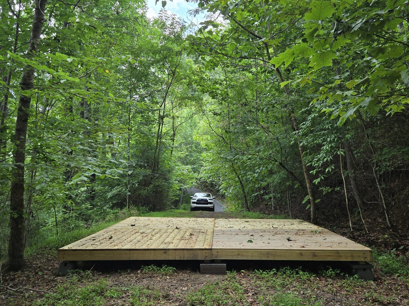 The tent deck at Pisgah 16, Cardinal Mountain Campground, with the driveway running back behind it